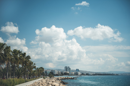 Beautiful town situating near endless sea and under bright sky with white clouds. Landscape conceptの写真素材