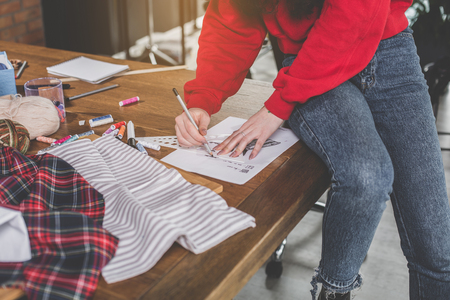 Close up female hands leading pencil while creating pattern of modern clothesの写真素材