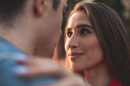 Close up focus on female face. Young girl is looking at man with true love and care. She is enjoying his companyの写真素材