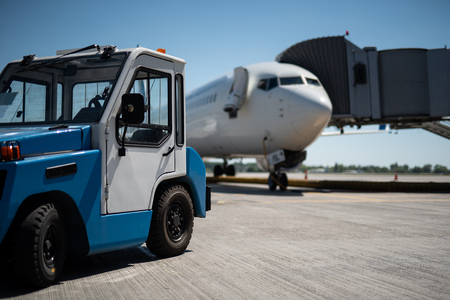 We ready for the flight. Close up of mini work car and passenger airplane. Copy space in right sideの写真素材