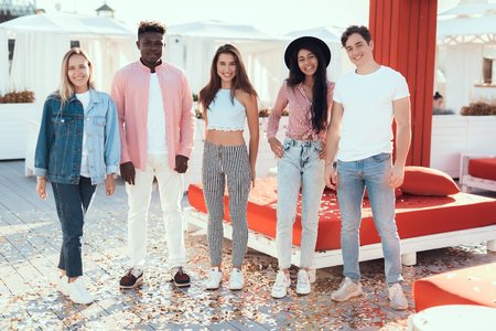 Full length portrait of cheerful men and outgoing girls standing together during sunny day after good partyの写真素材