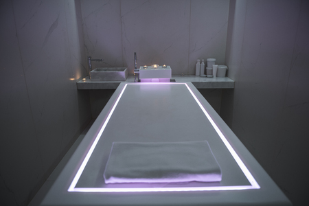 Place for relaxation. Massage table with soft towel and beautiful illumination in wellness centerの写真素材