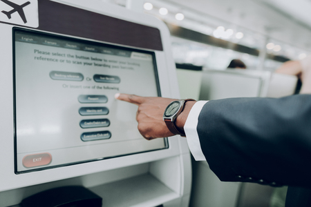 Tap here. Close up of male hand is pointing on the screen of information terminal insideの写真素材