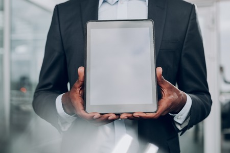 Check this out. Close up of male hands holding table, while standing in the officeの写真素材