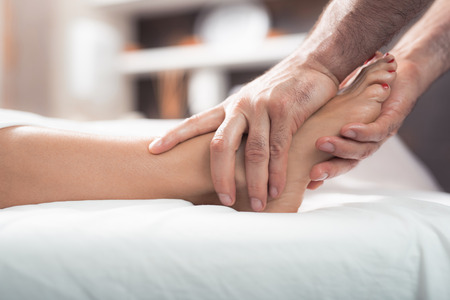 My weekend at spa. Close up of male therapist hands kneading woman foot during spa procedureの写真素材