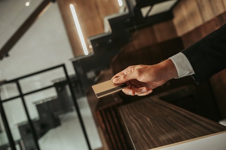 Payment passed successfully. Close up male employee hand giving credit card.の写真素材