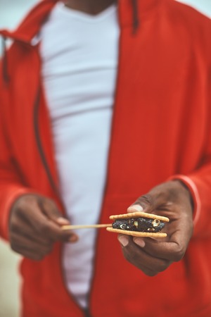 Sweet pastry. Close up of human hand holding cracker with fillingの写真素材