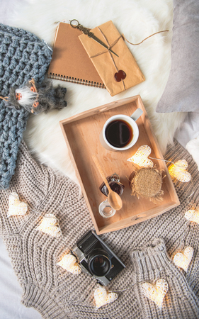Top view cup of coffee and jar of jam in salver. Envelop, gadget and sweater locating near it. Lunch conceptの写真素材