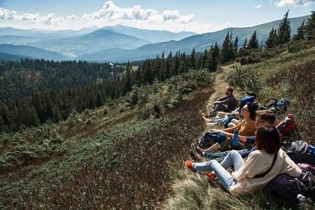 Pano shot of a beautiful Carpathian scenery with a group of travelers resting on the hillsの写真素材