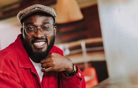 Positive man. Cheerful emotional bearded man wearing warm clothes and smiling while looking at youの写真素材