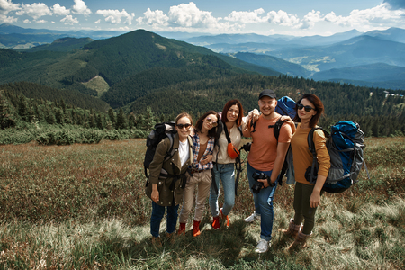 Top view full length portrait of four women and man standing and hugging.の写真素材