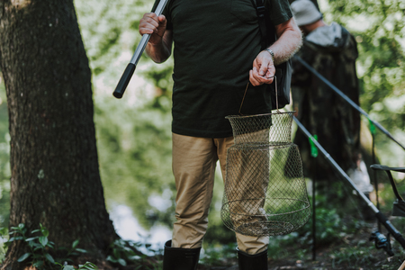 Close up of fishing equipment in hands of a man ready for anglingの写真素材
