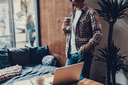 Cropped photo of mature man in street style clothes standing in comfort cafe with lovely interior.の写真素材