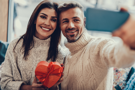 Lovely and beautiful couple sitting in small cafe with light interior.の写真素材