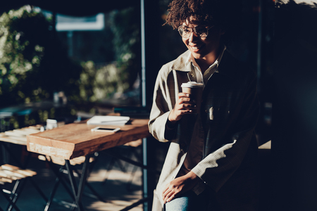 Beautiful lady holding paper cup with beverage and smiling.の写真素材