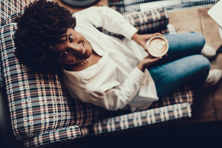 High angle photo of pretty gorgeous woman with smile. She sitting in cafe and looking up on cameraの写真素材