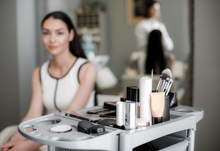 Beautifull lady sitting in beauty zone. Focus on professional expensive cosmetic