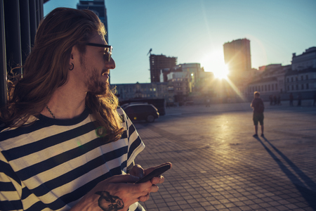 Waist up of a young male hipster standing in urban areaの写真素材