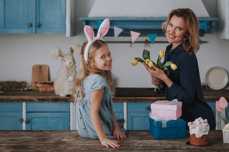 Little girl and mom with bunch of yellow tulips