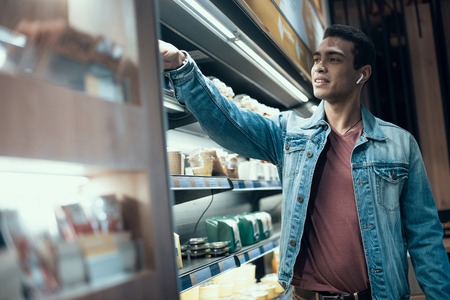 Handsome afro american guy buying groceries in supermarketの写真素材