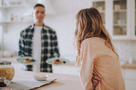 Long haired woman and man standing with plates on the background