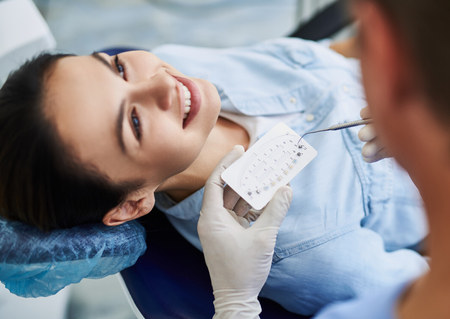 Competent dentist choosing braces for young womanの写真素材