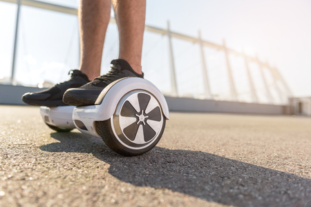 Close up of two male feet on modern gyro scooter
