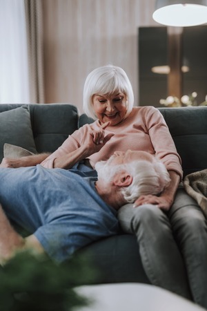 Happy elder couple having fun together on sofa