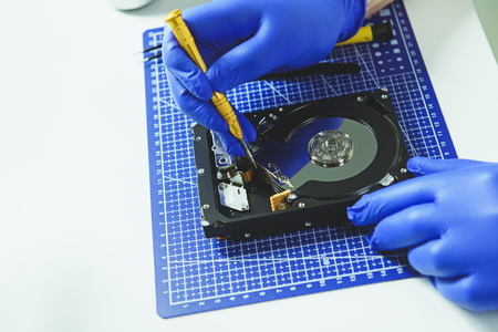 Engineer in protective gloves repairing computer HDDの写真素材