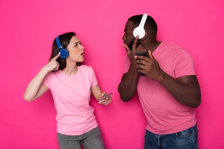 Half length of young interracial couple wearing modern headphones in studioの写真素材