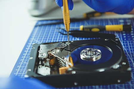 Close up of screwdriver and computer HDD on white backgroundの写真素材