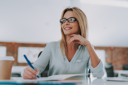 Happy businesswoman sitting in her office and smilingの写真素材
