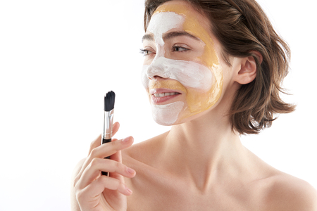 Cute smiling woman with face mask and brushの写真素材