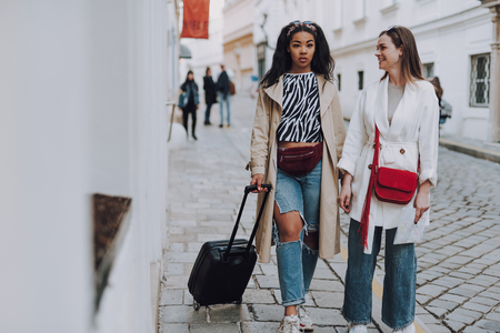 Two beautiful elegant women walking on the streetの写真素材