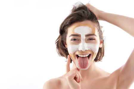 Portrait of happy funny female with face maskの写真素材