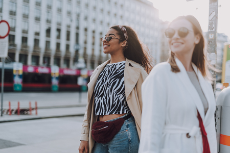 Two beautiful young women in sunglasses standing on the streetの写真素材