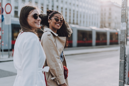 Joyful young women in sunglasses standing on the streetの写真素材