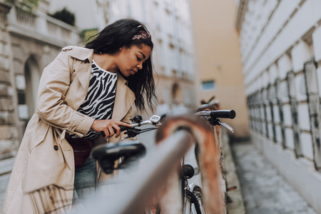 Beautiful afro american woman looking at bicycleの写真素材