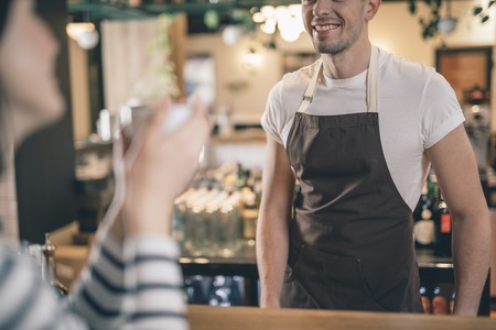 Close up of smiling male barista at the bar counterの写真素材
