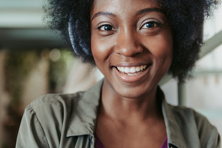 Portrait of happy African woman wearing headphones and listening to musicの写真素材