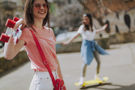 Close up happy hipster girl with penny boardの写真素材