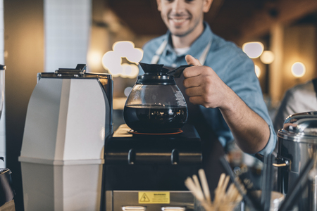 Selective focus of the coffee jug warming up at the bar counterの写真素材