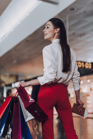 Cheerful woman is shopping before flying abroadの写真素材