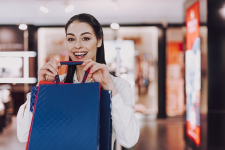 Laughing cute lady with paper bags in handsの写真素材