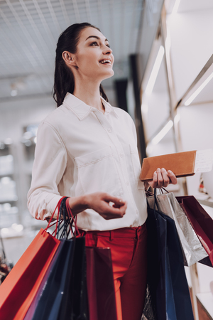 Cheerful woman is buying things in duty free boutiqueの写真素材