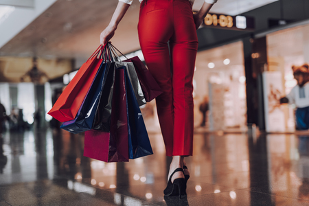 Elegant woman is carrying bags on way to planeの写真素材