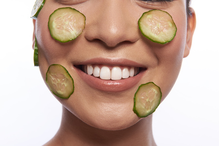 Lower part of woman face with cucumber slices on itの写真素材