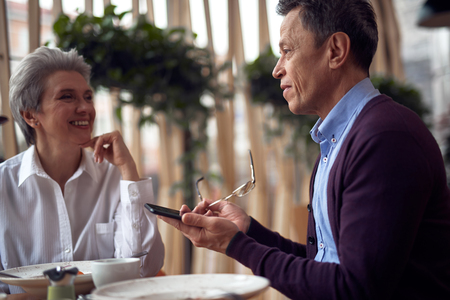 Happy aged woman listen her friend with interestの写真素材
