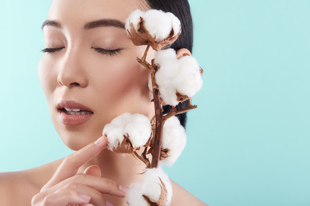 Close up of attractive Asian lady with closed eyes posing for cameraの写真素材