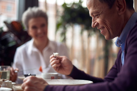 Smiling man having dinner in cafe with womanの写真素材